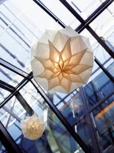White paper lanterns hanging from a glass ceiling