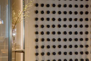 Black spheres arranged on a textured wall in an interior design setting.