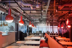 Modern industrial restaurant interior featuring exposed metal and geometric patterns.