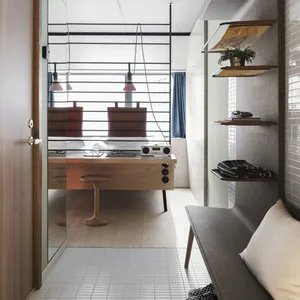 Modern minimalist office with wood desk, glass partition, and metal accents.