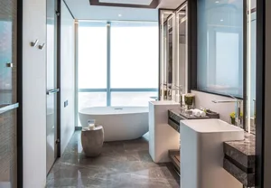 Modern bathroom featuring marble elements and featuring a spacious bathtub and double sinks.