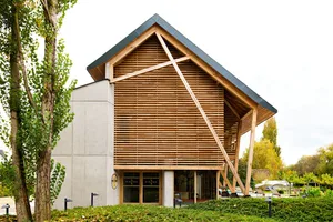 A modern building exterior featuring a wooden facade and concrete walls.