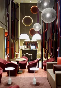 A modern hotel lounge featuring unique lighting fixtures and contemporary seating arrangements.