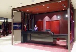 現代酒店接待櫃檯，擁有流線設計、紅色強調牆與金屬櫃檯。