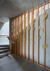 Modern stairwell featuring vertical wooden slats and concrete structural elements.