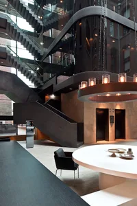 Industrial-style lobby with black walls and glass stairs