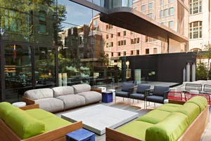 Modern outdoor lounge area with sofas, chairs, and tables.