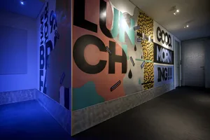 A corridor wall decorated with colorful paint splashes and motivational phrases.