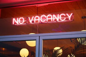 A neon sign reading 'NO VACANCY' outside a hotel or restaurant.
