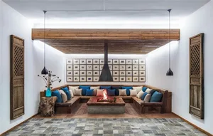 A modern industrial living room with a cozy fireplace, sectional sofa, and overhead lighting.
