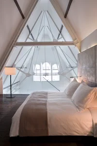 A minimalist bedroom with a bed, window, and floor lamp.