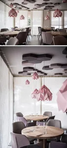 A minimalist restaurant interior featuring modern, geometric paper light fixtures hanging from the ceiling.