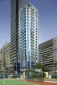 A modern apartment building with glass and concrete materials.