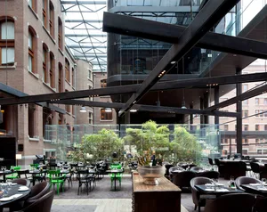 A stylish, modern cafeteria with glass walls and concrete flooring.