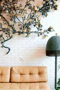 A modern interior space featuring a brick wall adorned with a metal floral arrangement, adding a touch of elegance and sophis