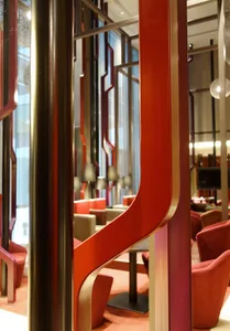 A modern lobby featuring sleek metallic columns and red acrylic elements