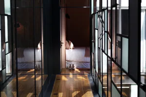 Minimalist bedroom with wooden floor and glass walls