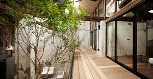 Industrial architectural design featuring wooden flooring, glass windows, and concrete walls.