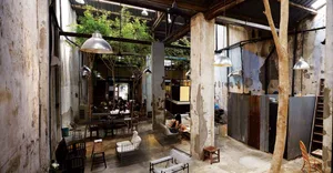 A rustic industrial cafe interior with concrete walls, steel accents, and glass partitions.