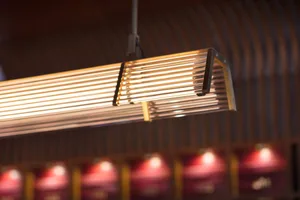 Long metal rods suspended from the ceiling to create an industrial-style lighting fixture.