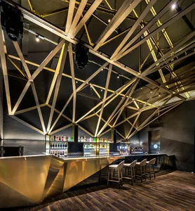 A modern bar interior featuring metal and glass materials.