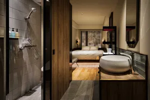 A modern bedroom featuring wooden flooring and minimalist decor.