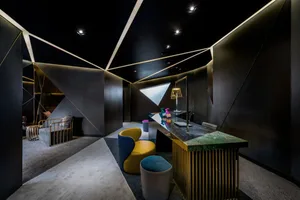 An industrial-style lounge area featuring metal and wood furniture, with a mix of modern and vintage elements.