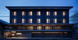 Modern residential building with wooden exterior at dusk with lights on inside