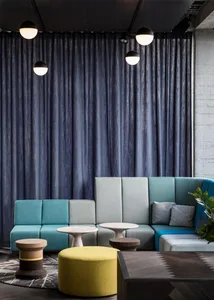 Modern restaurant with a textured concrete wall, concrete tables, and a blue chair.
