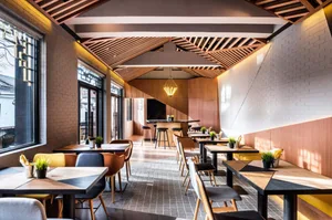 A modern restaurant interior featuring wood and brick materials.