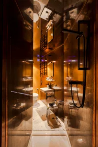 A modern, industrial-style bathroom with metallic finishes and minimalist design.