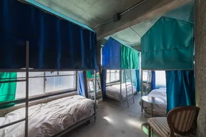 A cozy, industrial-style camping hut interior with metal and cotton-blend materials.