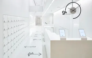 A minimalist commercial space featuring a white interior with white lockers, white cubicles, and a white reception desk.