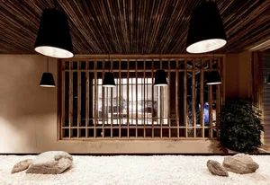 Minimalist interior space featuring bamboo ceiling and stone decor.