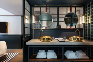 Modern bathroom with metallic gold sinks and mirrors