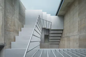 An interior design image depicting a modern set of concrete stairs.