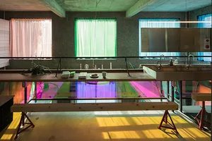 A modern interior space featuring a mix of materials and vibrant colors, with a focus on a colorful glass feature.