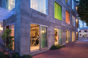 Contemporary office interior with concrete walls and glass doors.