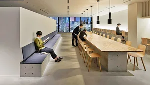 A modern office space featuring seating areas with wood and concrete materials.