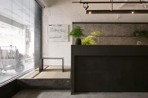 An industrial-style coffee shop interior featuring concrete flooring and minimalist design.