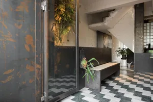 Industrial style lobby interior with metal, glass, and concrete elements.