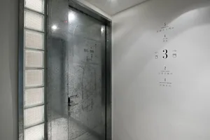 Metallic glass door with industrial design in a corporate setting.