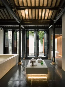 A minimalist bathroom with concrete tile flooring and timber walls.
