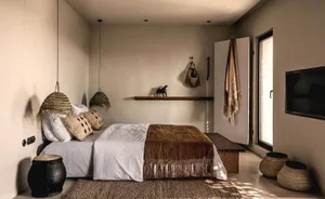 Bedroom featuring minimalist design with natural fiber textiles, wooden elements, and earthy tones.