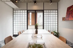 A minimalist office space featuring concrete, metal, and glass materials.