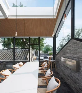 Modern minimalist restaurant interior with wooden furniture and large glass windows.