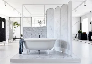 Modern bathroom featuring a white bathtub and marble tiles, showcasing contemporary design elements.
