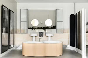 A modern bathroom featuring a curved bathtub made of wood and a countertop with two sinks.