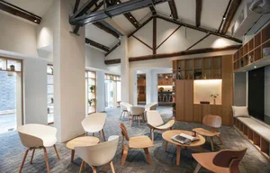 Modern cafe interior with wooden chairs, concrete flooring, and metallic accents.