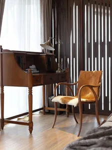 A vintage wooden desk and chair in a home office setting.